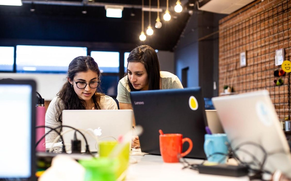 Dos participantes trabajando juntas frente a una computadora